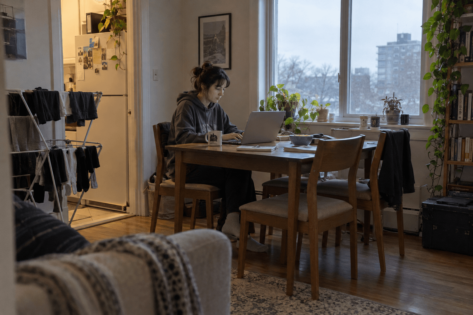 Une jeune personne remplit des documents sur son ordinateur à la maison.