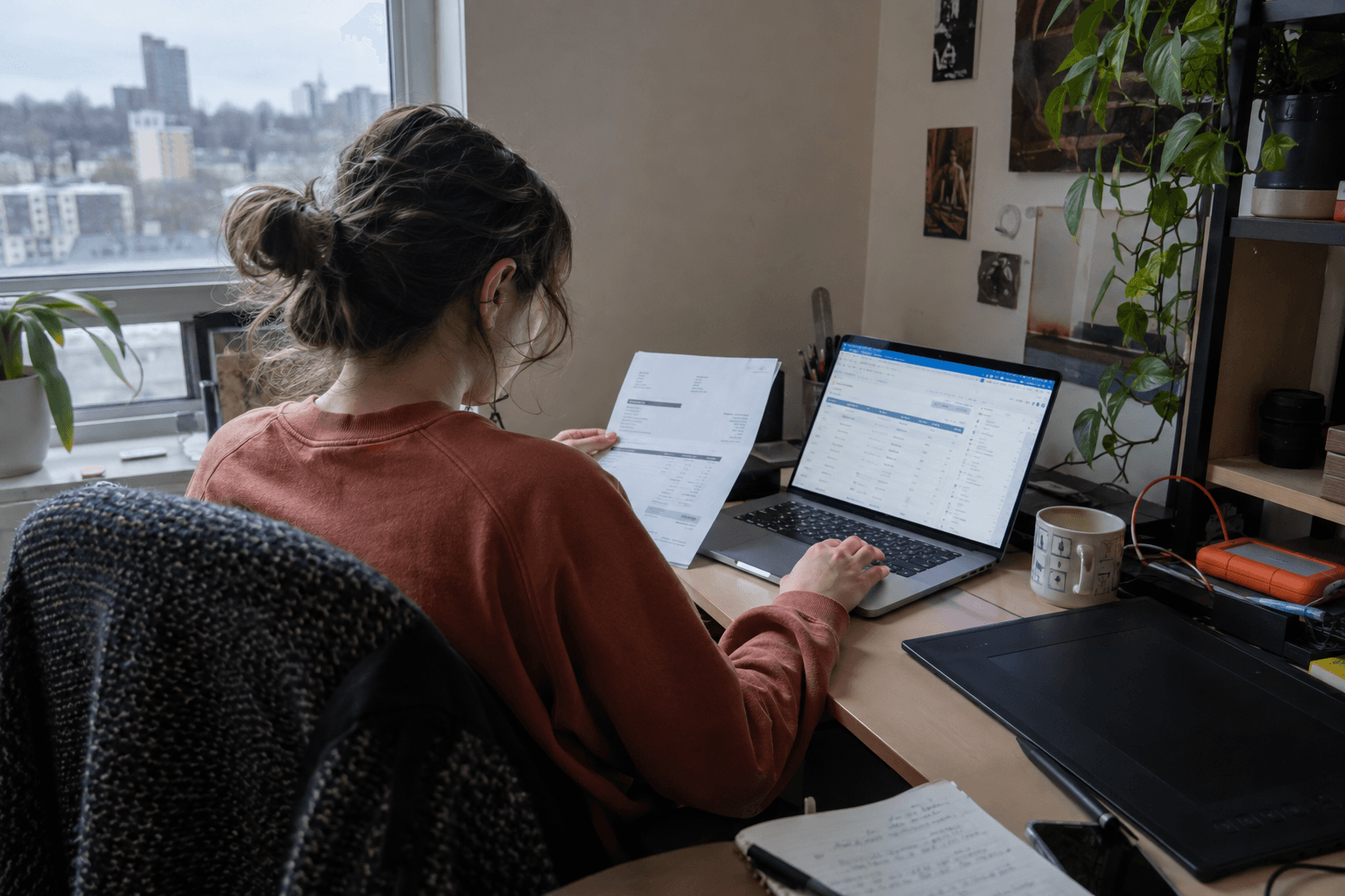 Une personne à son compte compare une facture à un relevé de paiement.
