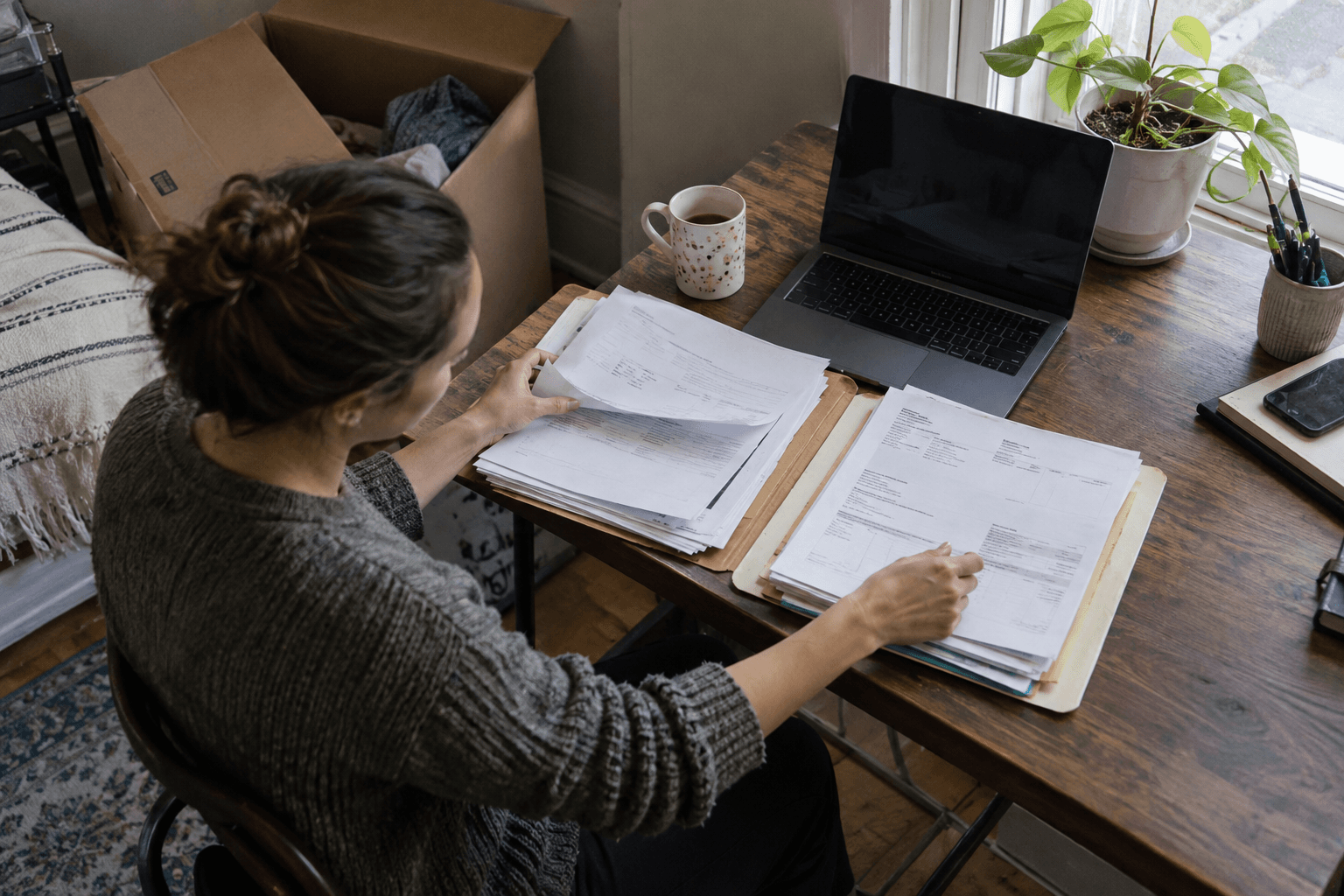 Income records from two folders compared at a desk.