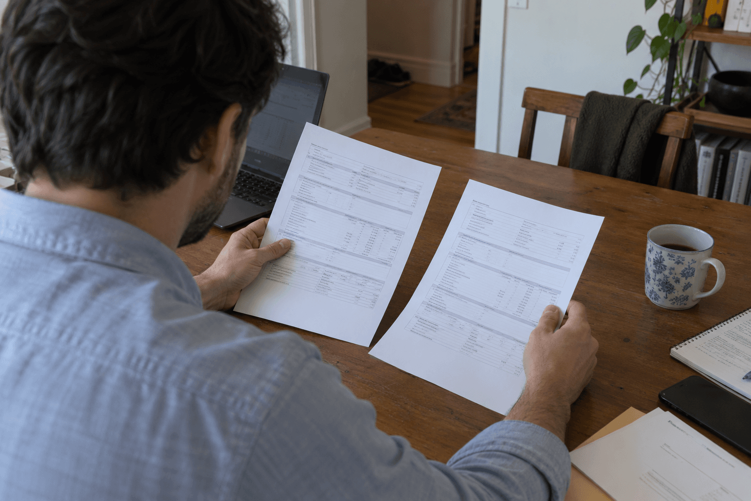 Two tax slips being compared at a dining table.